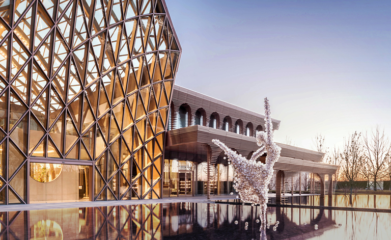 Focus on the fountain and statue in front of the exhibition hall.