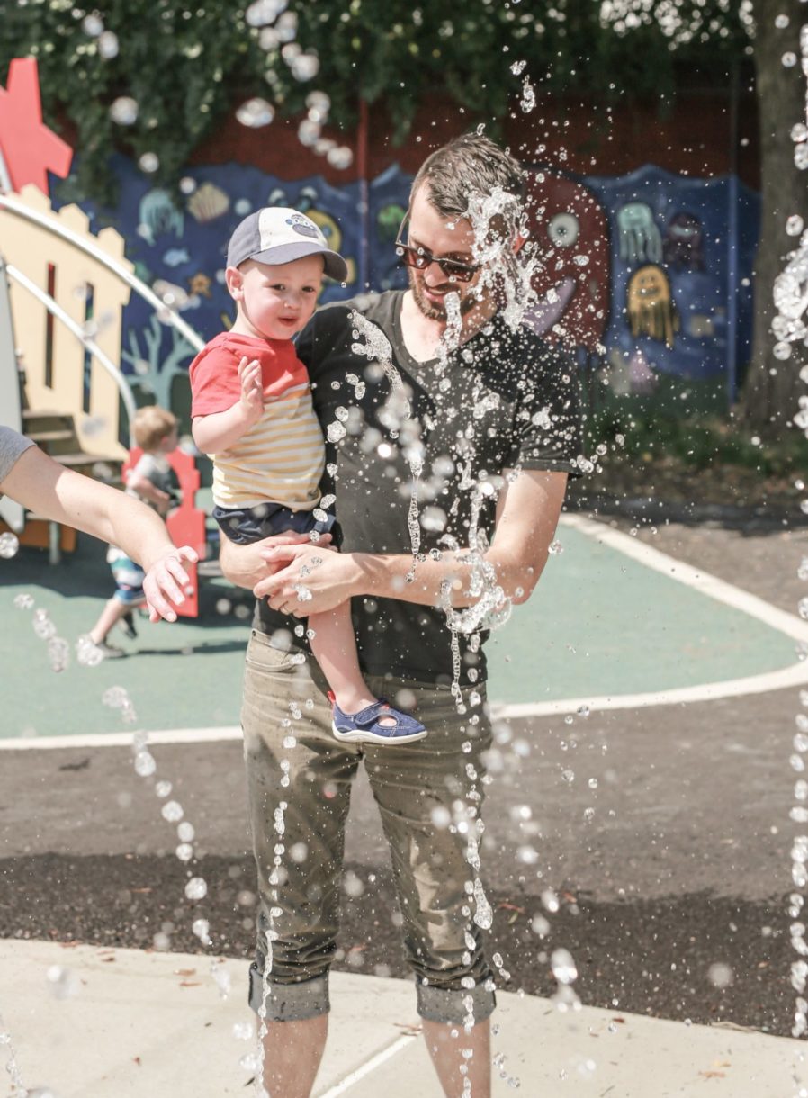 man with son in fountain